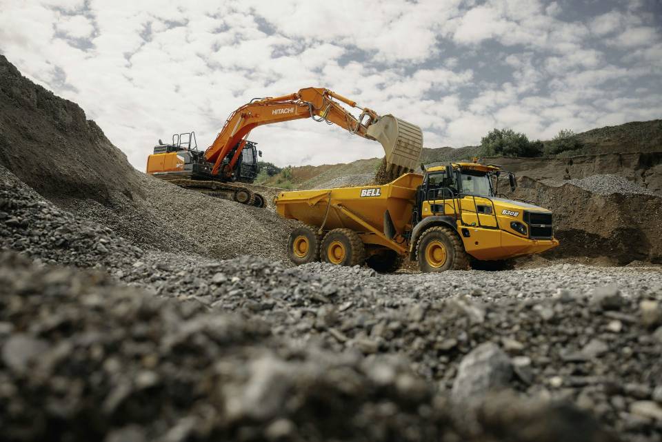 Excavator and dump truck working in quarry.